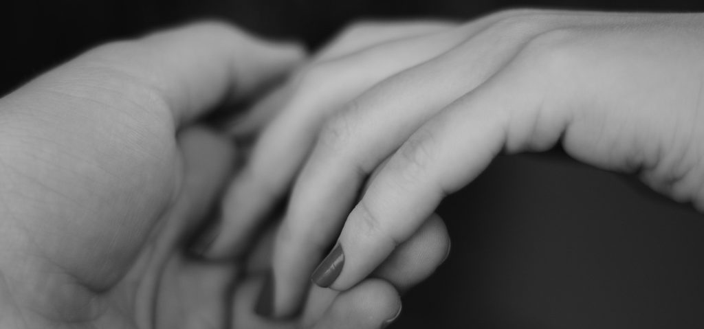 Two people holding hands gently —a quiet reminder that love can hold space for healing.