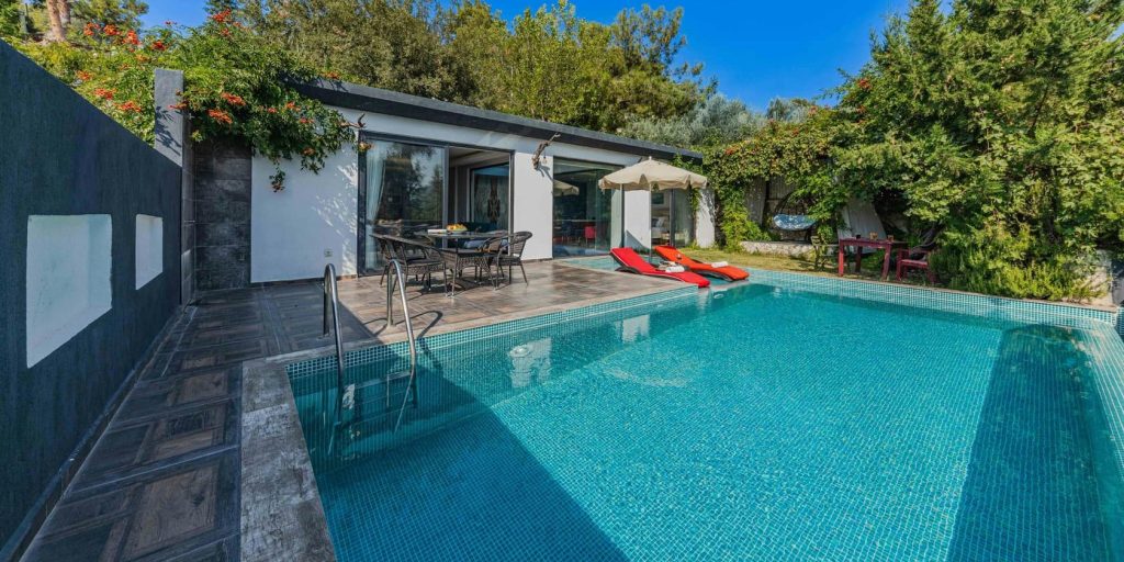A serene villa retreat with a sparkling private pool, surrounded by lush greenery and bright skies.